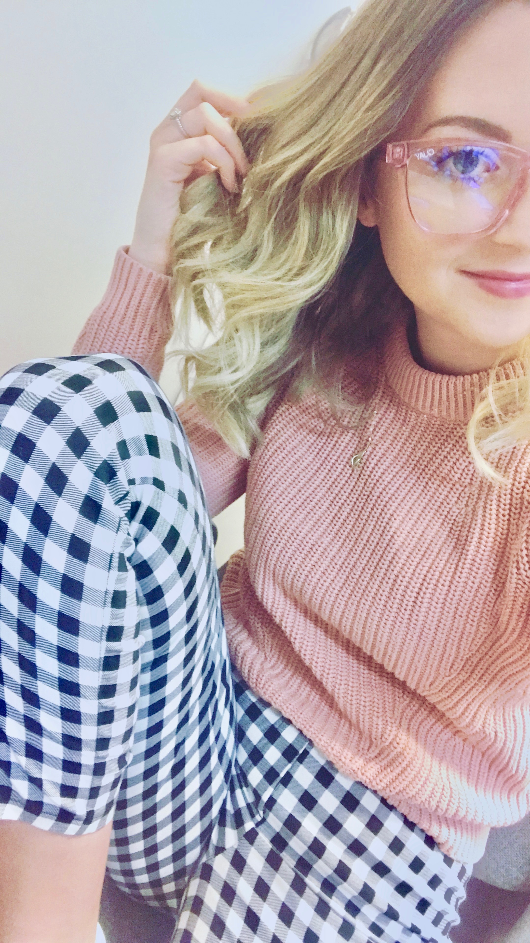 Girl wearing blue light filtering glasses with pink frames.