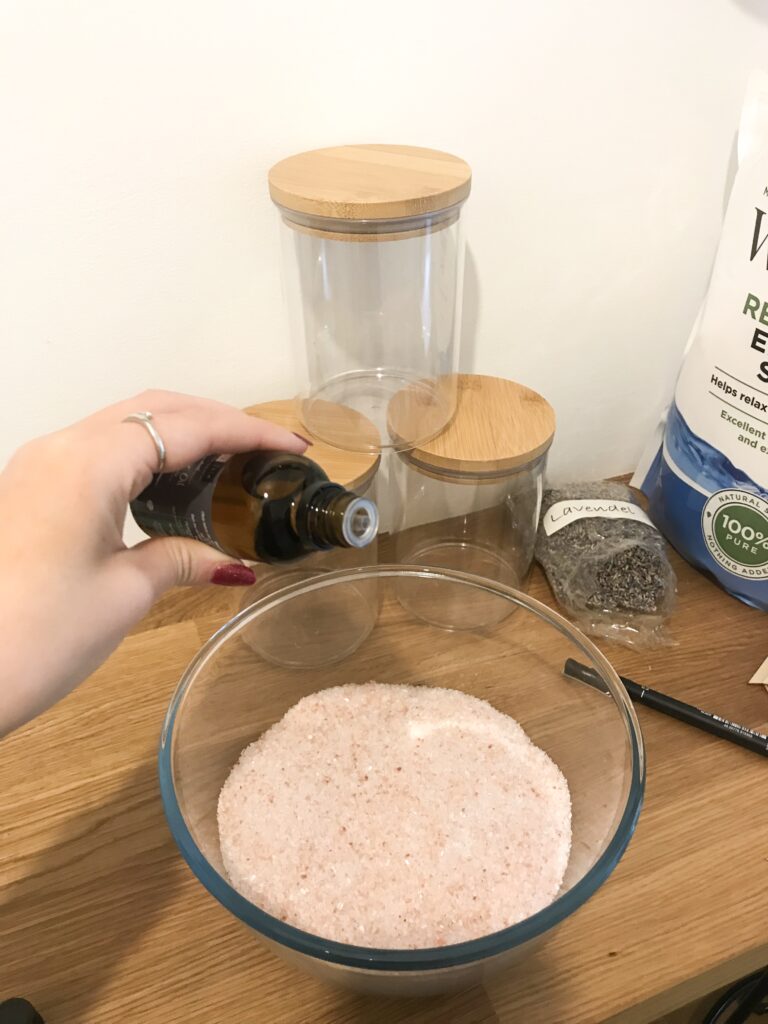 Pouring Lavender essential oil into bowl of salts
