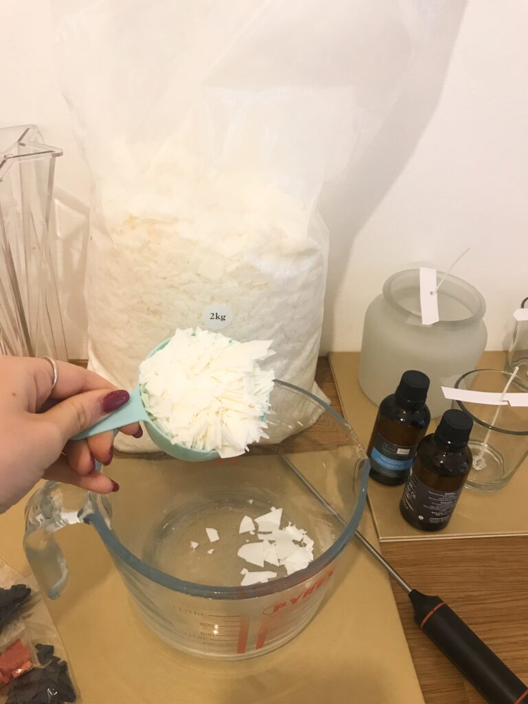 Pouring soy wax into a jug for melting