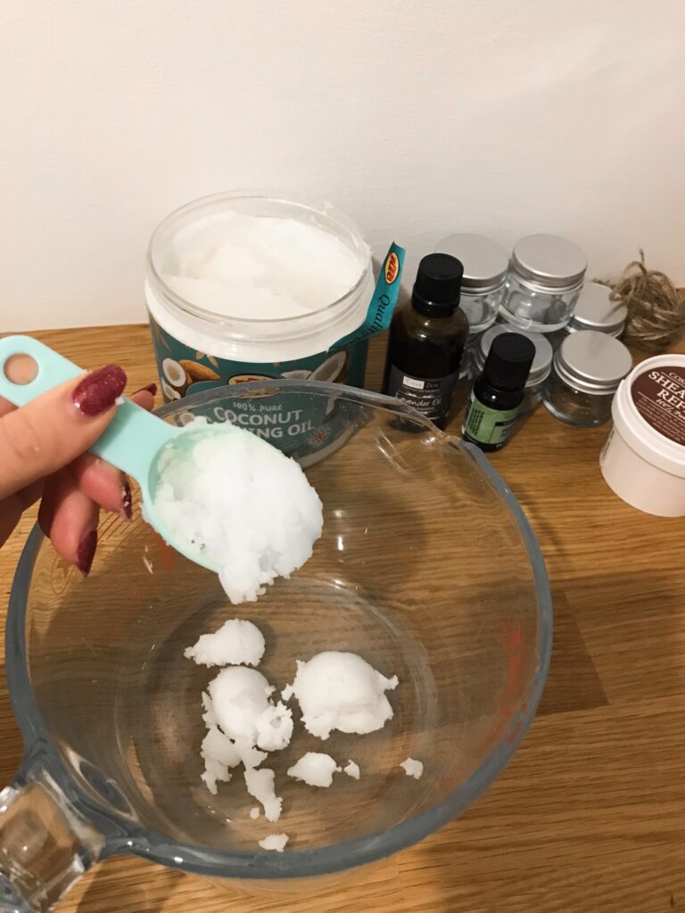 Scooping coconut oil into a jug
