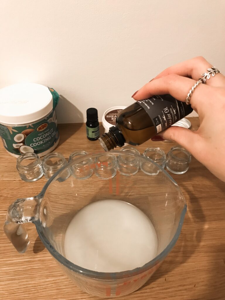 Adding essential oils to coconut oil and shea butter in a jug